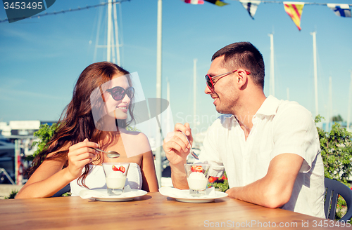 Image of smiling couple eating dessert at cafe
