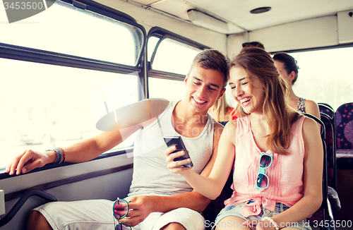 Image of smiling couple with smartphone making selfie