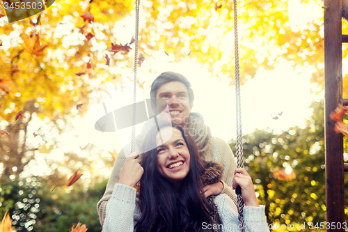 Image of smiling couple hugging in autumn park