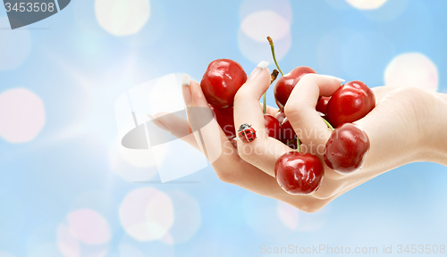 Image of female hand full of red cherries