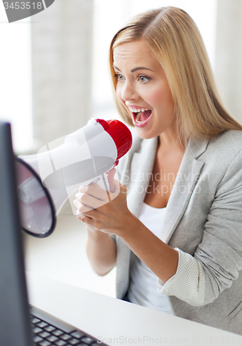 Image of crazy businesswoman shouting in megaphone