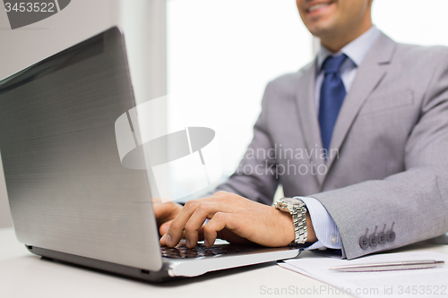 Image of close up of businessman with laptop and papers