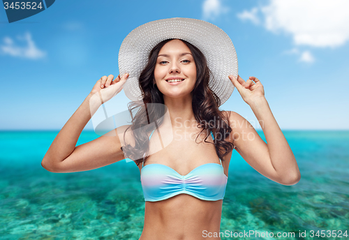 Image of happy young woman in bikini swimsuit and sun hat