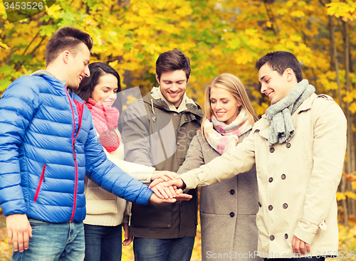 Image of group of smiling men and women in autumn park
