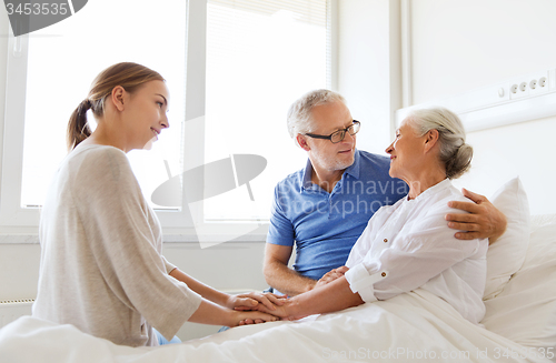 Image of happy family visiting senior woman at hospital