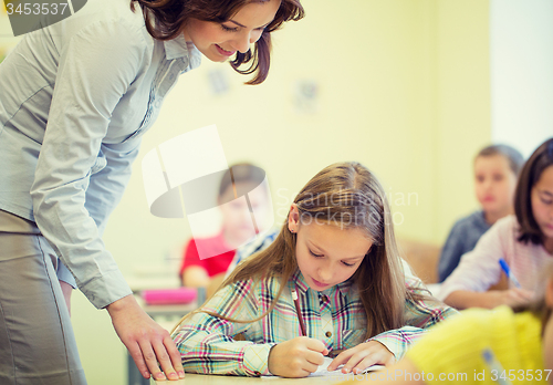 Image of group of school kids writing test in classroom