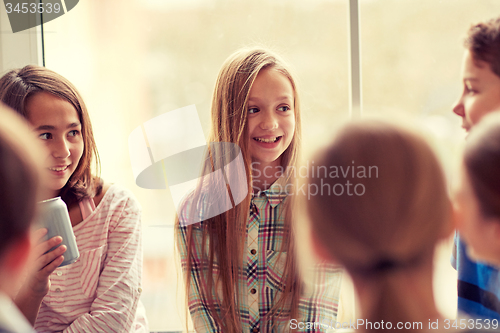 Image of group of school kids with soda cans in corridor