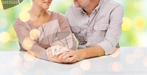 Image of close up of senior couple holding hands