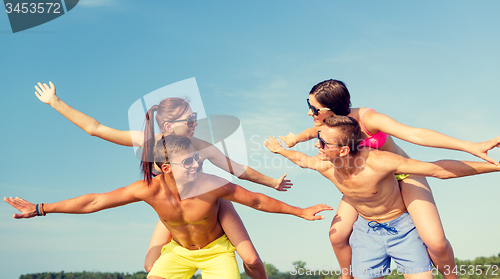 Image of smiling friends having fun on summer beach