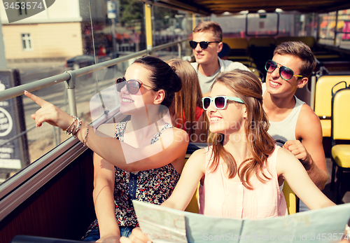 Image of group of smiling friends traveling by tour bus