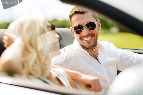 Image of happy man and woman driving in cabriolet car