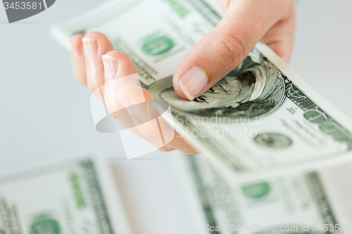 Image of close up of woman hand counting us dollar money