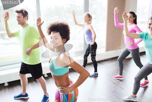 Image of group of smiling people dancing in gym or studio