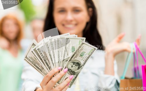 Image of close up of woman with shopping bags and money