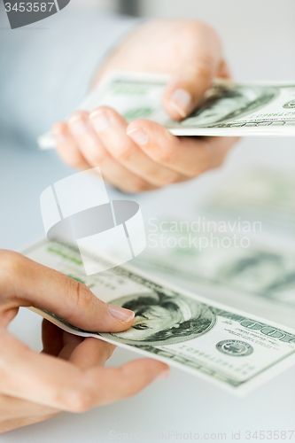 Image of close up of woman hands counting us dollar money