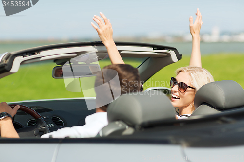 Image of happy man and woman driving in cabriolet car