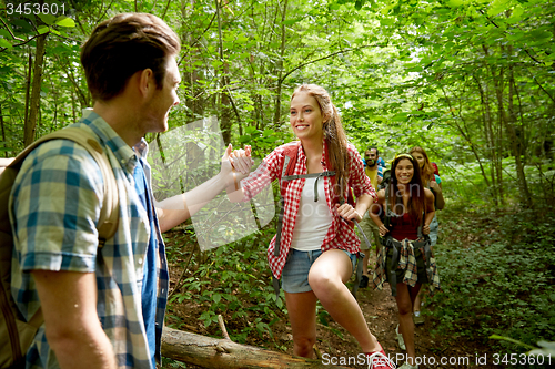 Image of group of smiling friends with backpacks hiking