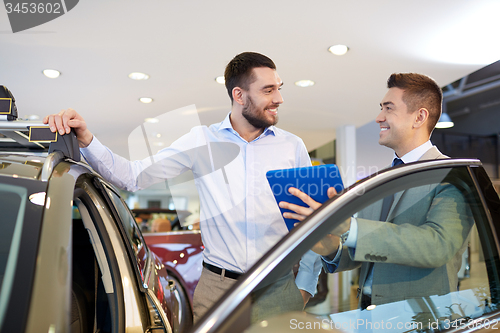 Image of happy man with car dealer in auto show or salon