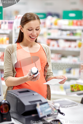 Image of happy pregnant woman with medication at pharmacy