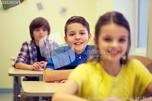 Image of group of school kids with notebooks in classroom