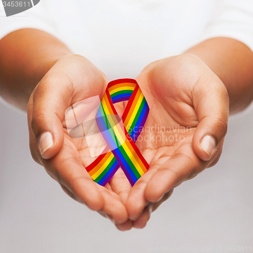 Image of hands holding rainbow gay pride awareness ribbon