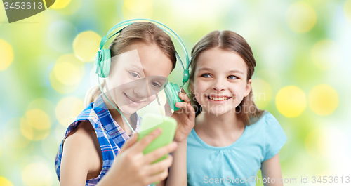 Image of happy girls with smartphone and headphones