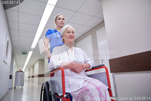 Image of nurse with senior woman in wheelchair at hospital