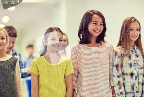 Image of group of smiling school kids walking in corridor