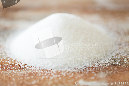 Image of close up of white sugar heap on wooden table