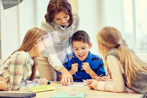 Image of group of school kids writing test in classroom