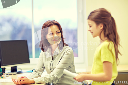 Image of school girl with notebook and teacher in classroom