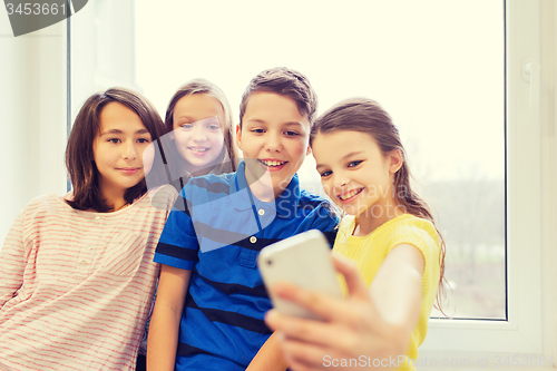 Image of group of school kids taking selfie with smartphone