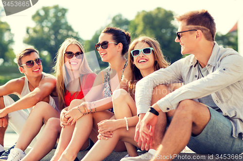 Image of group of smiling friends sitting on city street