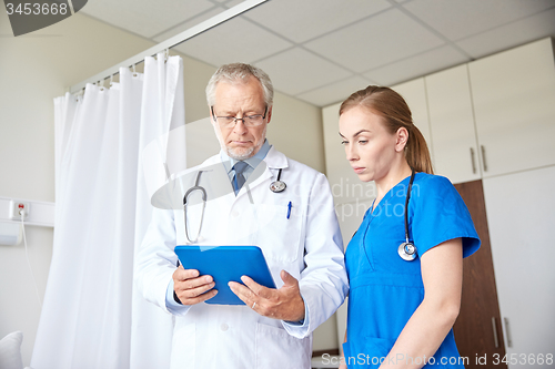 Image of senior doctor and nurse with tablet pc at hospital
