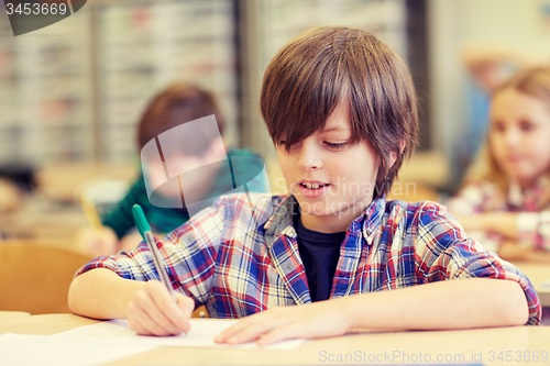 Image of group of school kids writing test in classroom