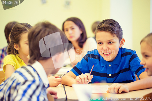 Image of group of school kids writing test in classroom