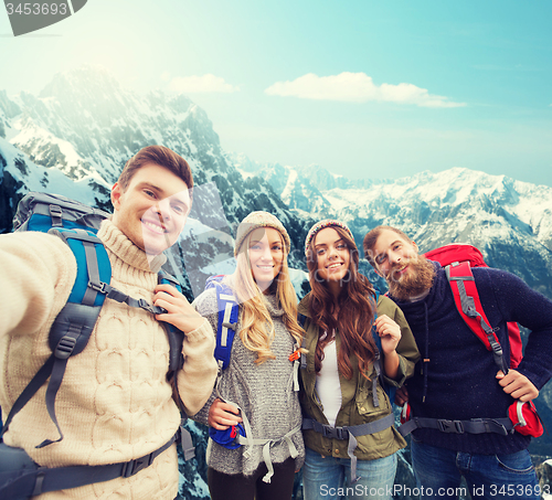 Image of group of smiling friends with backpacks hiking