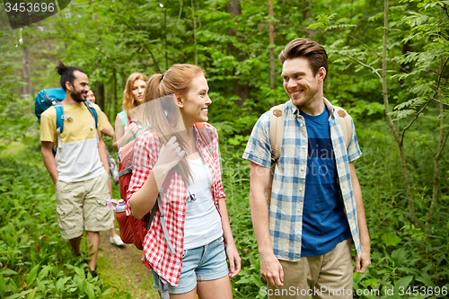 Image of group of smiling friends with backpacks hiking