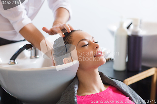 Image of happy young woman at hair salon