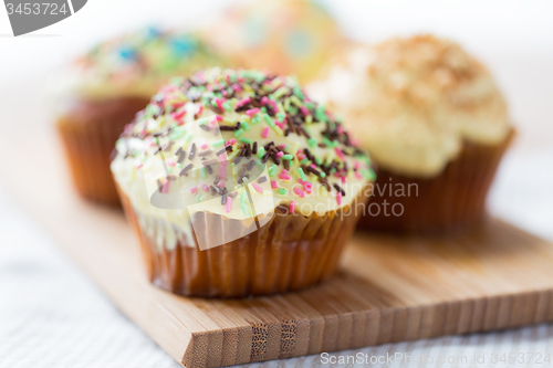 Image of close up of glazed cupcakes or muffins on table