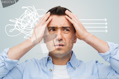 Image of unhappy man with closed eyes touching his forehead