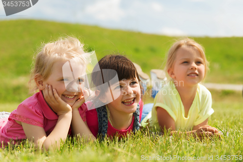 Image of group of kids lying on blanket or cover outdoors