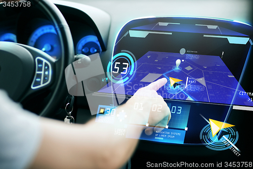 Image of male hand using navigation system on car dashboard