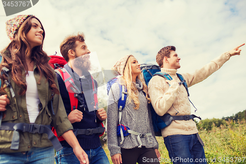 Image of group of smiling friends with backpacks hiking