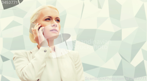 Image of serious businesswoman with smartphone outdoors