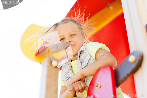 Image of happy little girl climbing on children playground