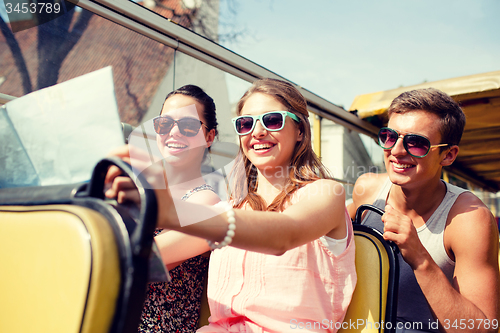 Image of group of smiling friends traveling by tour bus