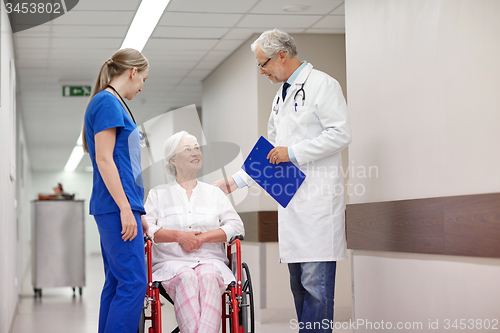 Image of medics and senior woman in wheelchair at hospital