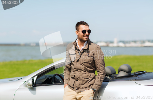 Image of happy man near cabriolet car outdoors