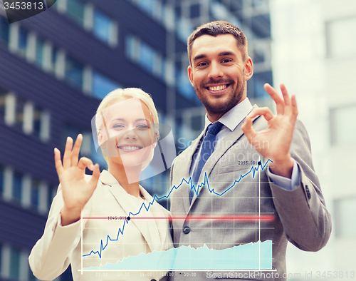 Image of smiling businessmen standing over office building